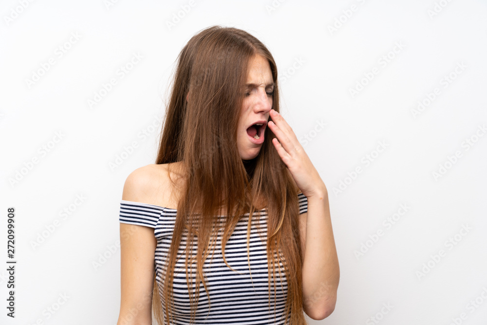 Young woman with long hair over isolated white wall yawning and covering wide open mouth with hand Young woman with long hair over isolated white wall yawning and covering wide open mouth with hand