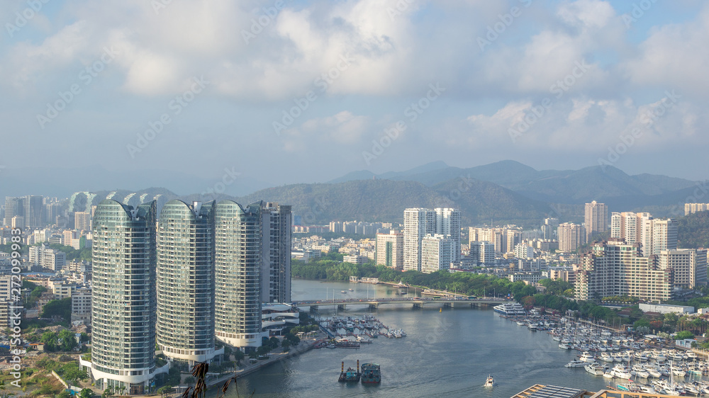 View of one of the districts of Sanya city. Visible are the skyscrapers and the public ferry terminal. Hainan Island, China.