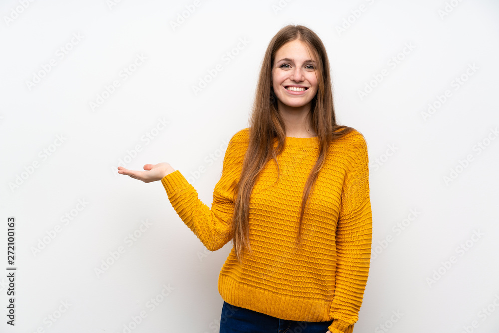 Young woman with yellow over isolated white wall holding copyspace imaginary on the palm Young woman with yellow over isolated white wall holding copyspace imaginary on the palm