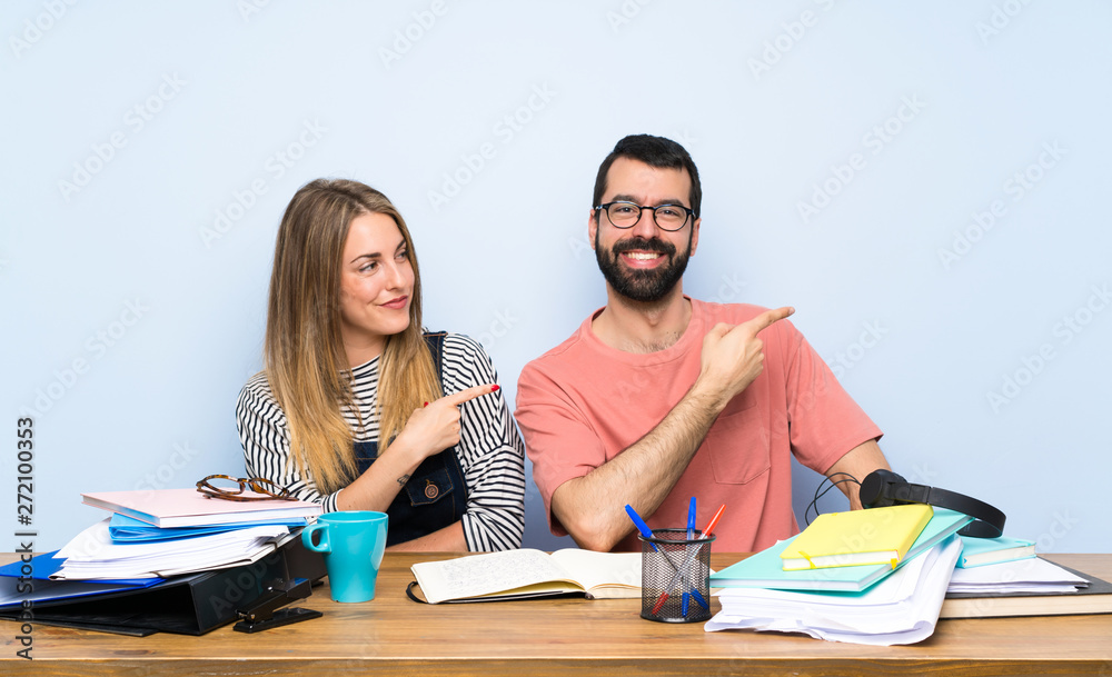 Students with many books pointing finger to the side Students with many books pointing finger to the side