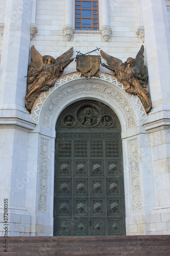 Church facade entrance door with decorative statues and ornaments 
