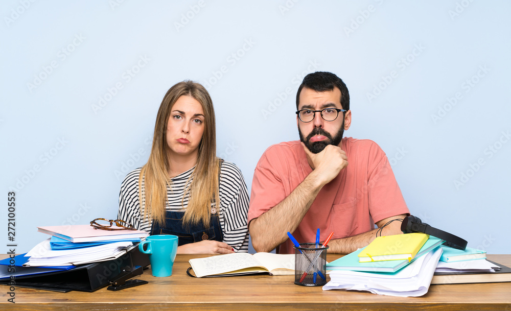 Students with many books with sad and depressed expression Students with many books with sad and depressed expression