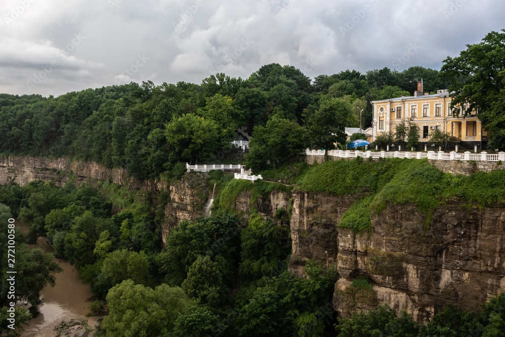 Canyon of the Smotrych River in Kamianets-Podilskyi, covered with green forest, after rain. The river is visible below. Ukraine.