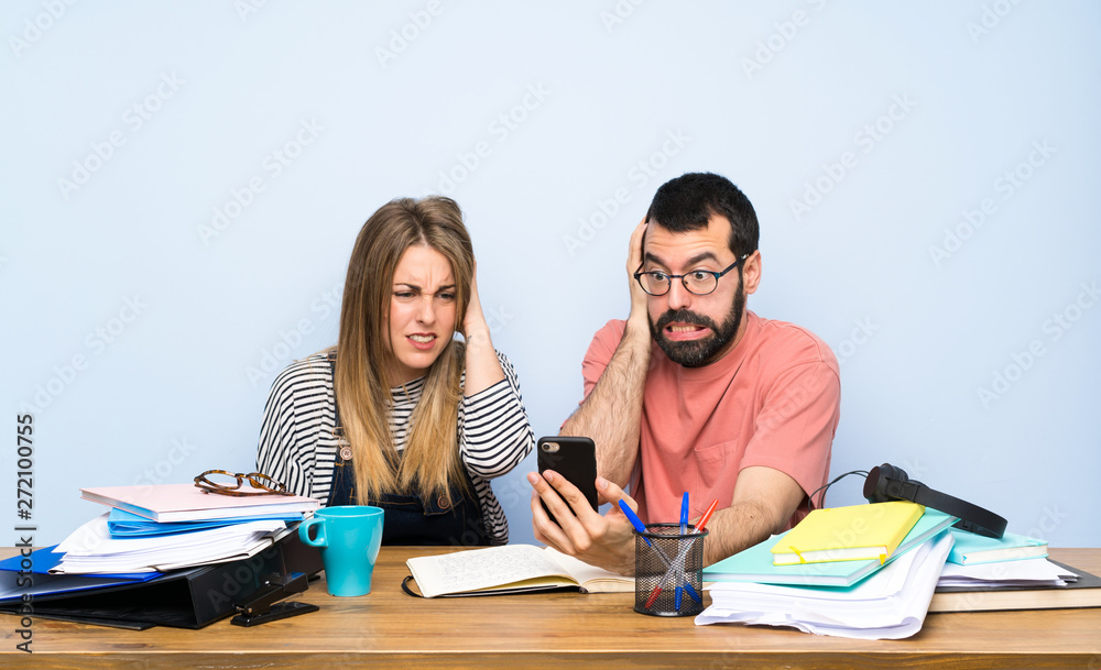 Two students with many books and stressed Two students with many books and stressed