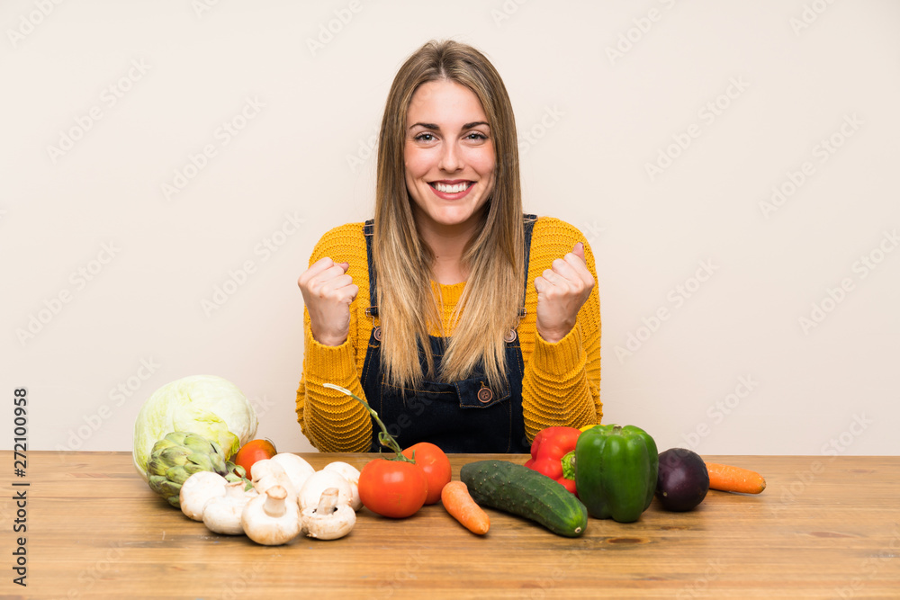 Fototapeta premium Woman with lots of vegetables celebrating a victory