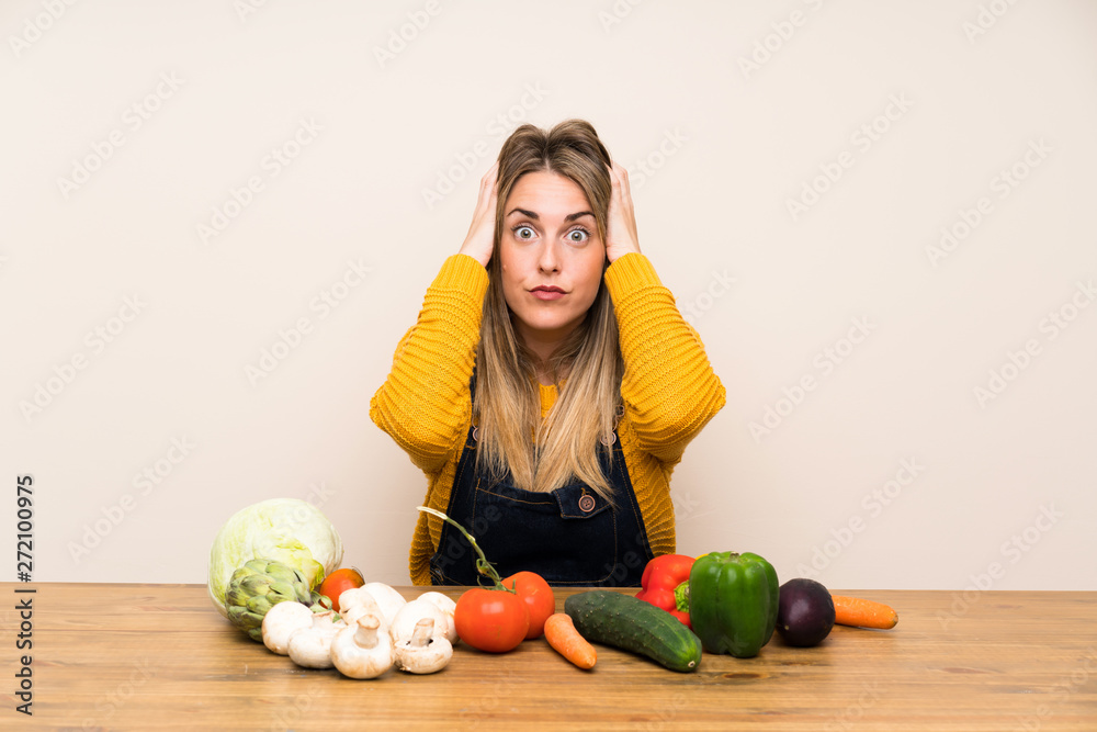 Fototapeta premium Woman with lots of vegetables with surprise facial expression