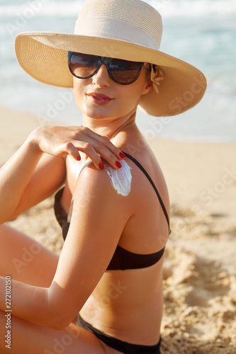 Beauty Woman smile applying sun cream  on shoulder. Skincare. Body Sun protection. sunscreen. Female Using moisturizing lotion on skin.Skin Protection and dermatology
