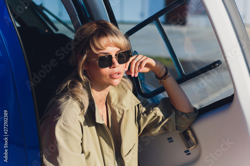 Female pilot in cockpit of helicopter before take off. Young woman helicopter pilot. photo