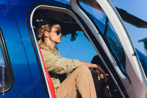 Female pilot in cockpit of helicopter before take off. Young woman helicopter pilot. photo