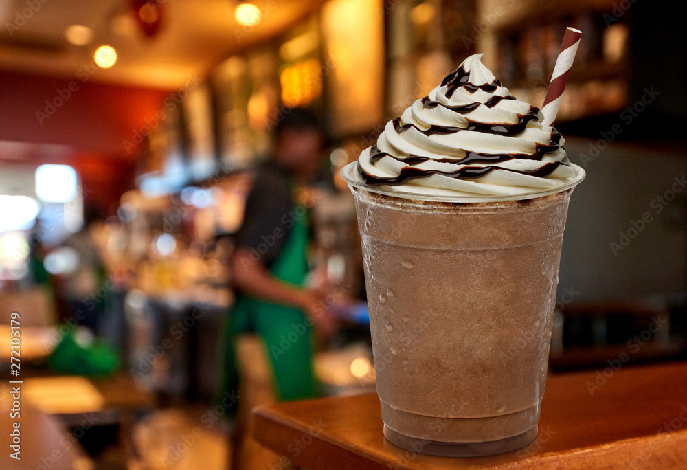 Cup of frappuccino coffee with cream and chocolate sauce on wooden counter at cafe. Cup of frappuccino coffee with cream and chocolate sauce on wooden counter at cafe.