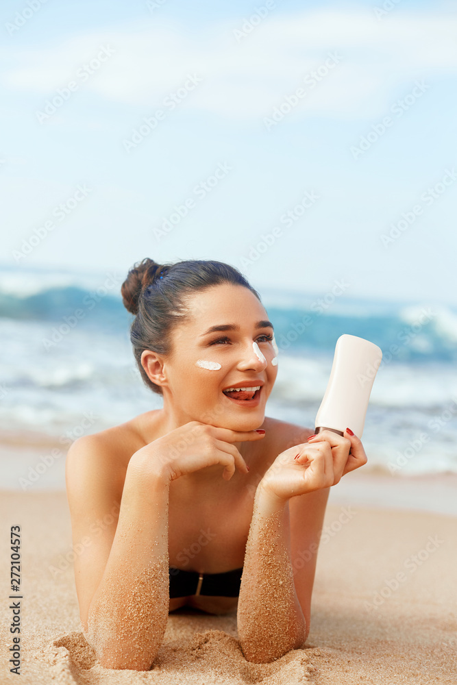 Beauty Woman Skin care sunscreen holding bottles in her hands. Girl  applying sun cream on face. Sun protection. Moisturizer Facial treatment.  Stock Photo