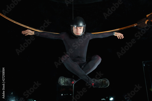 levitation in black suit in aerotube