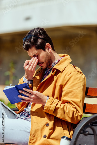 Tired businessman holding notebook and tablet