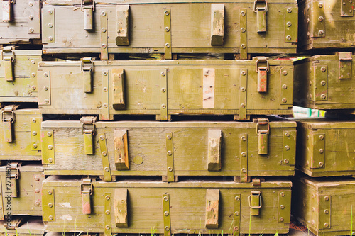 Billede på lærred Military green boxes with dangerous explosives, guns and military weaponry, ready for shipping, in a munition producing factory