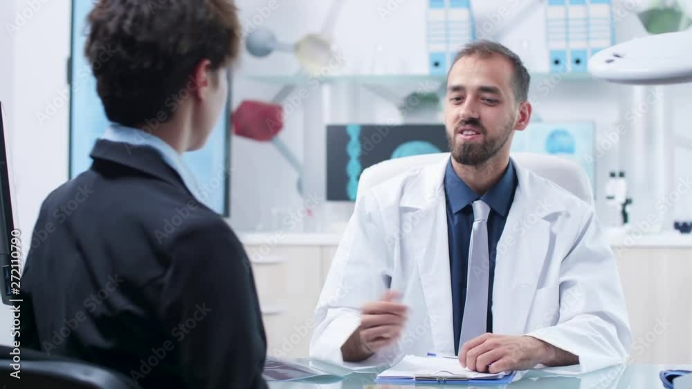 In modern facility scientist in white robe is having a conversation with a candidate. High end equipment running 3D brain simulation and DNA strings In modern facility scientist in white robe is having a conversation with a candidate. High end equipment running 3D brain simulation and DNA strings