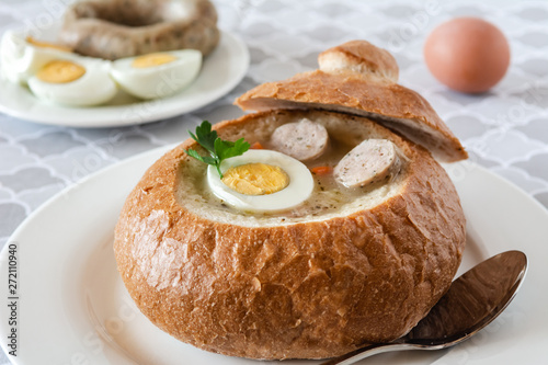 The sour soup (zurek) made of rye flour with sausage and egg served in bread bowl. Popular Easter dish.