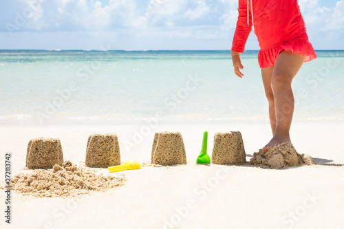 Girl Breaking The Sandcastle With Leg At Beach