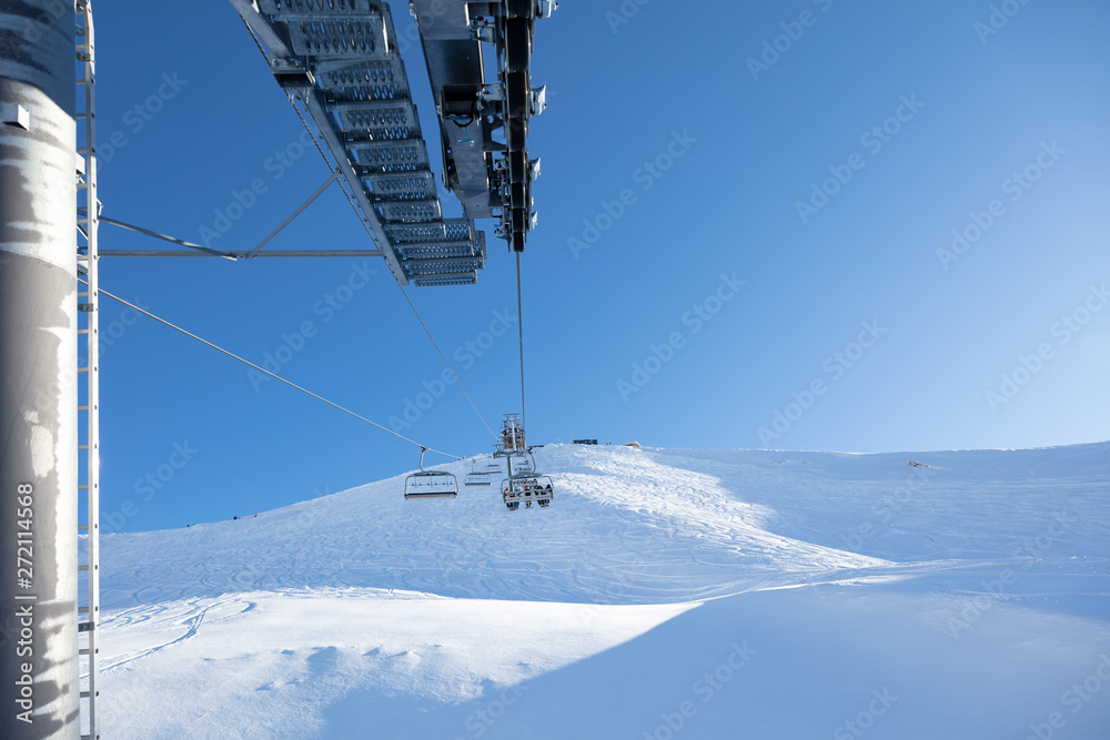 Ski lift seen from the pole against blue sky Ski lift seen from the pole against blue sky