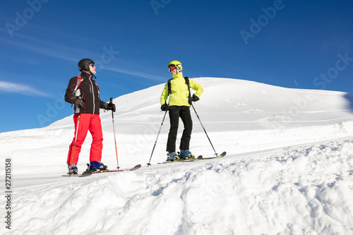 Skier couple skiing on snowy landscape during winter