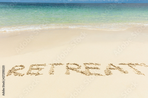 Retreat Text On Sand Near The Idyllic Sea At Beach photo