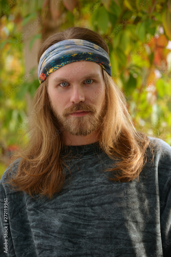 portrait of a young man with long hair and beard in a bandana Photos |  Adobe Stock