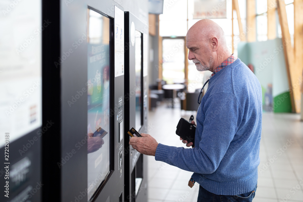Senior man paying contactless on a vending machine Senior man paying contactless on a vending machine