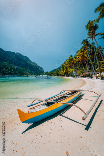 Traditional wooden banca boat on beautiful Las Cabanas beach. Summer vacations, Island hopping, El Nido, magic of Philippines