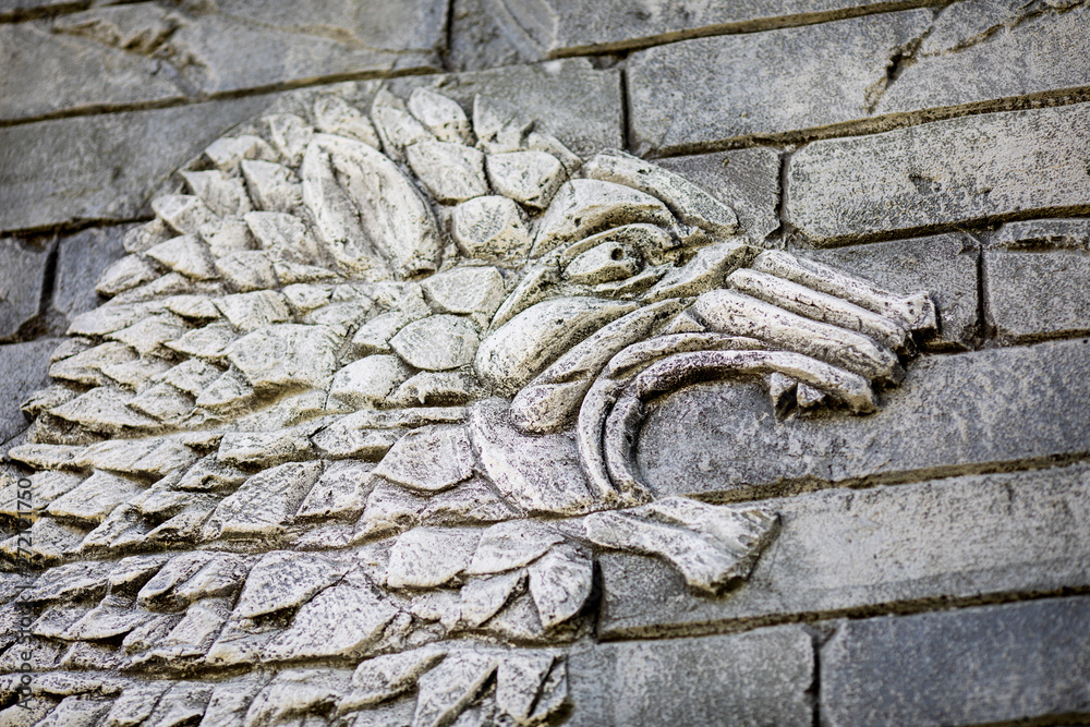 Ancient monster carved in stone on the wall, old decorative ornament