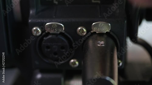 Hand disconnecting and connecting two xlr inputs on professional camera. 4k video macro shot