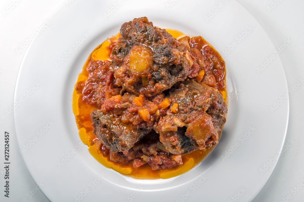 Isolated Dish with a portion of oxtail stewed vaccinara Isolated Dish with a portion of oxtail stewed vaccinara