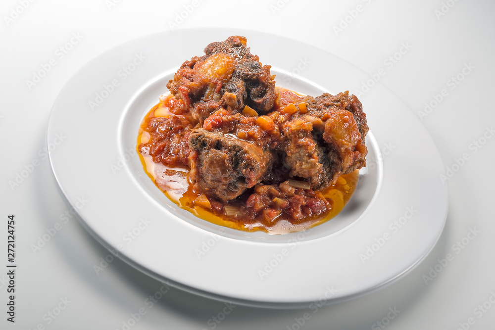 Isolated Dish with a portion of oxtail stewed vaccinara Isolated Dish with a portion of oxtail stewed vaccinara
