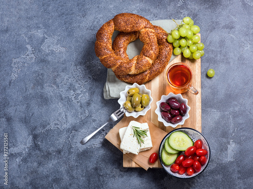 Traditional turkish breakfast with olives, simit bagels, feta cheese, tea, oriental snack on wooden board