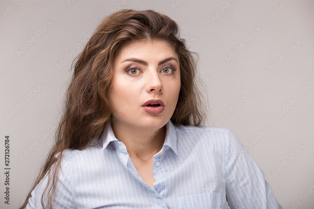 Obraz premium Happy suprised shocked excited girl face with long curly hair. Young caucasian woman isolated on white background. Copy space