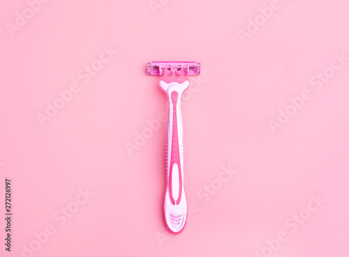 Body Depilation Disposable razor pink on a pink background. Selective focus. photo