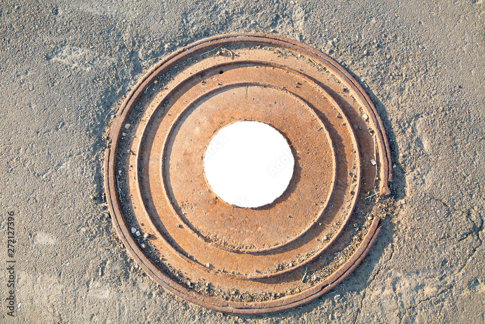 Manhole cast iron heavy brown with a pattern of several rings on the background of concrete screed. In the center of the round white background for photo inscription