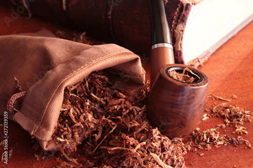 tobacco pipe tobacco pouch lighter and old book photo