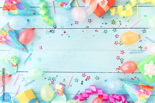 Party background top view. Festive multicolored decorations on blue wooden background toned. Flat lay style. Copy space