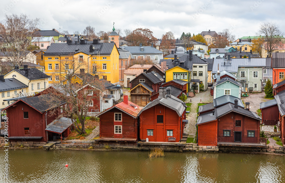 Obraz premium Porvoo town, Finland. Old red wooden houses on the river coast on a cloudy day