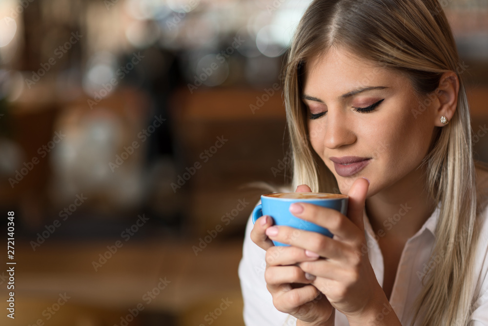 Close up of happy woman enjoying in the smell of fresh coffee in a cafe Close up of happy woman enjoying in the smell of fresh coffee in a cafe