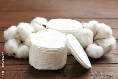 Composition with cotton pads and flowers on wooden background