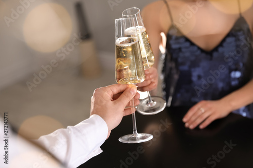 Man and woman clinking glasses of champagne at party, closeup