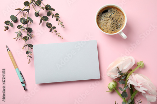 Flat lay composition with spring ranunculus flowers and card on color background. Space for text