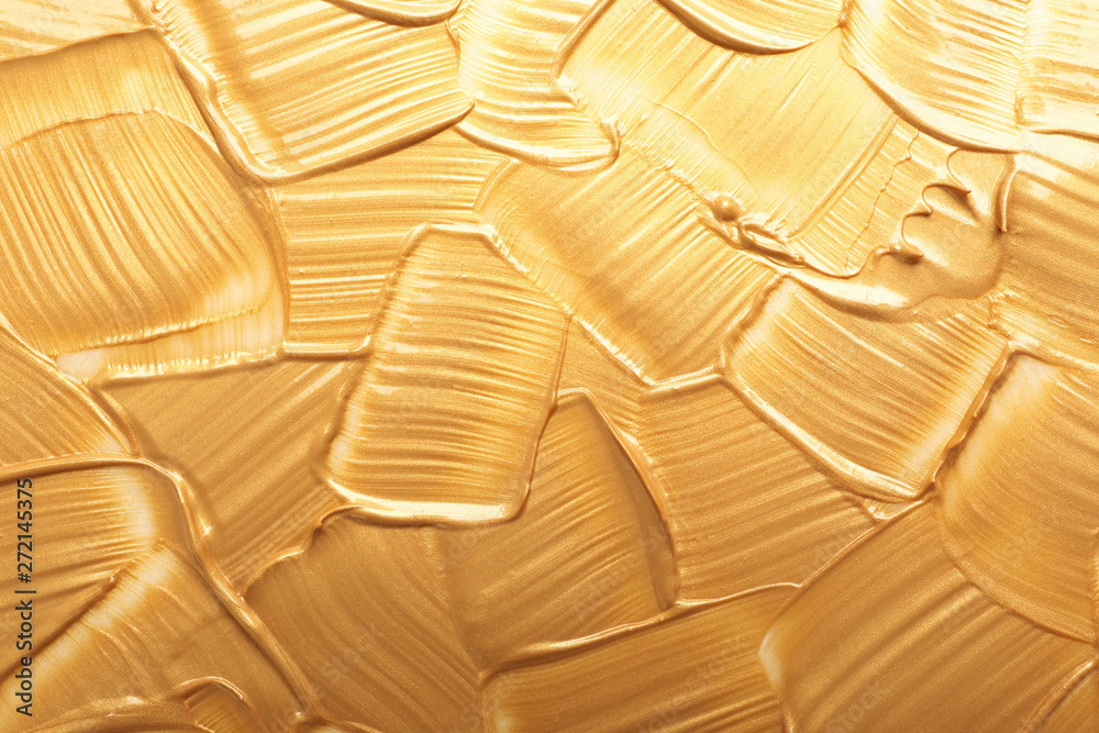 Fototapeta premium Strokes of gold paint as background, top view
