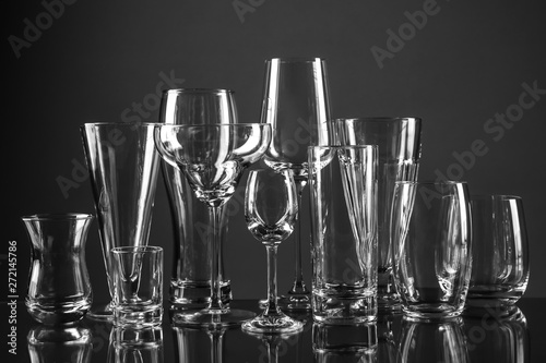 Empty glasses for different drinks on dark background