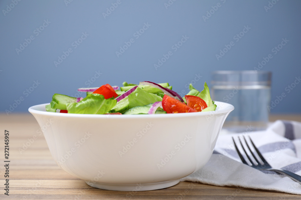 Bowl of tasty salad with cucumber, tomato and lettuce on table Bowl of tasty salad with cucumber, tomato and lettuce on table