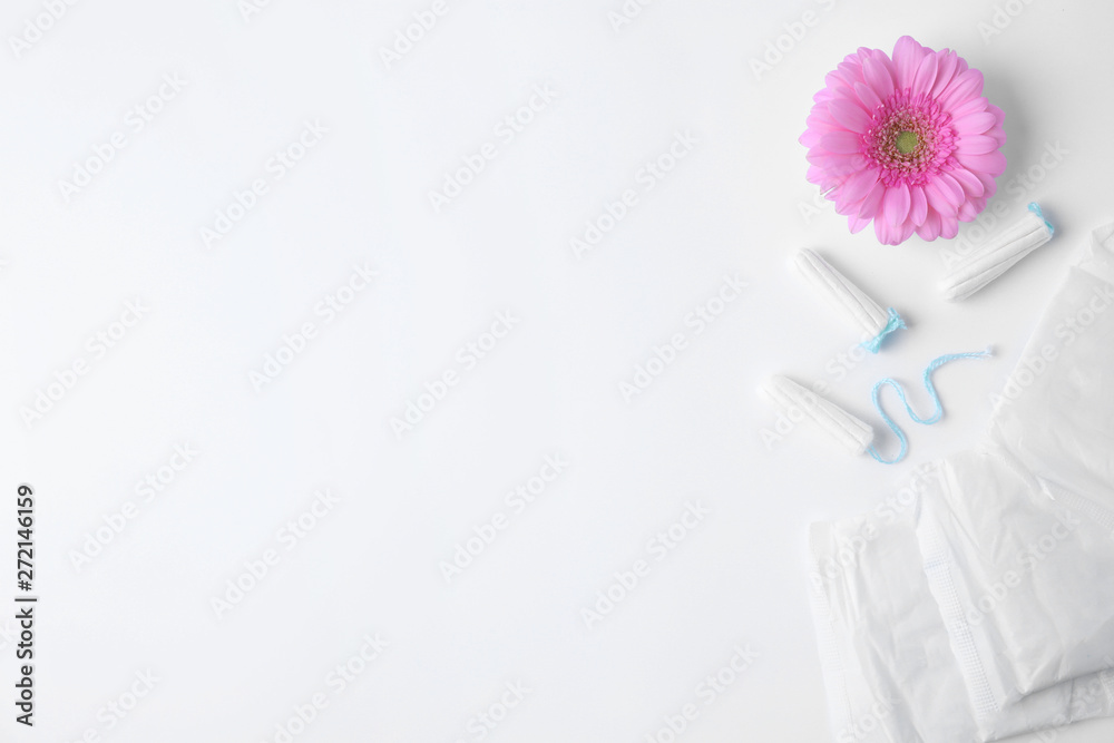 Different feminine hygiene products and flower on white background, top view with space for text. Gynecological care