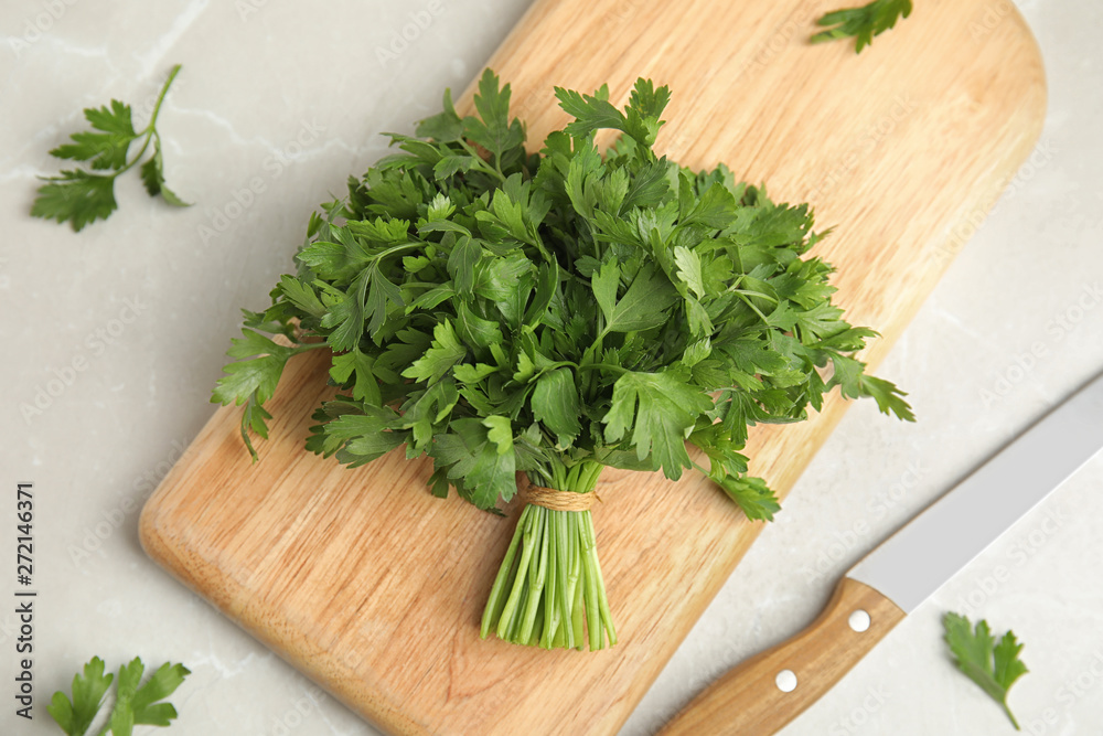 Board with fresh green parsley and knife on light background, top view Board with fresh green parsley and knife on light background, top view