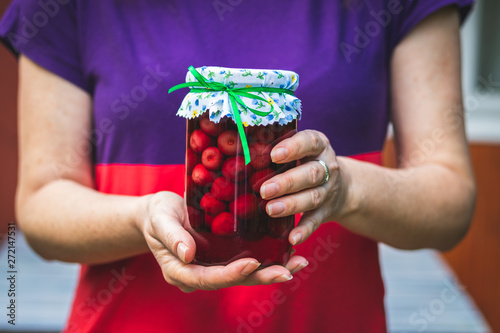 Woman holding cherry compote in hands