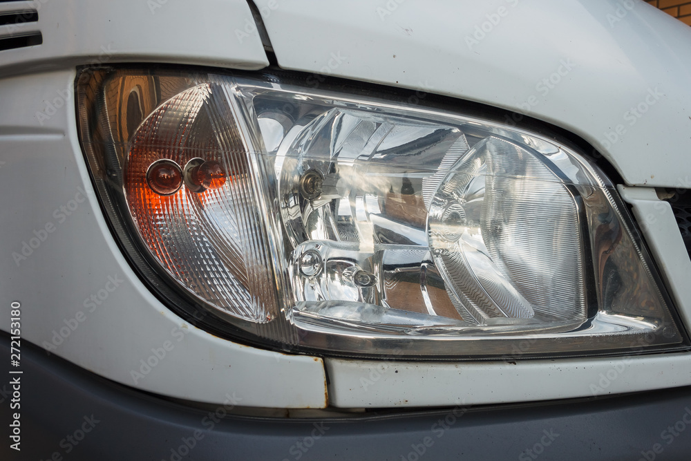 The dirty headlights of a car. Close-up