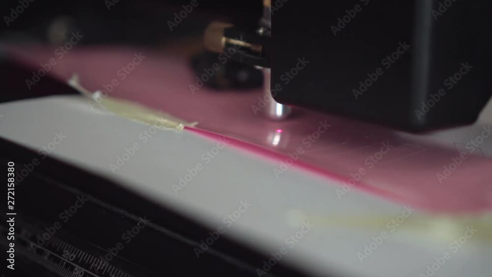 Cutting plotter. Plotter cuts pink vinyl, film. Laser cuts vinyl, film. Industrial equipment for cutting vinyl and film. Cutting plotter. Plotter cuts pink vinyl, film. Laser cuts vinyl, film. Industrial equipment for cutting vinyl and film.